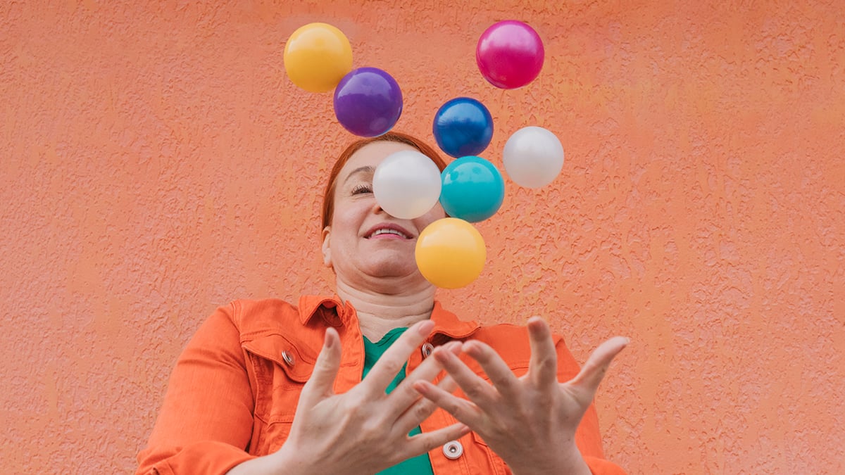 Mature woman juggling multicolored balls