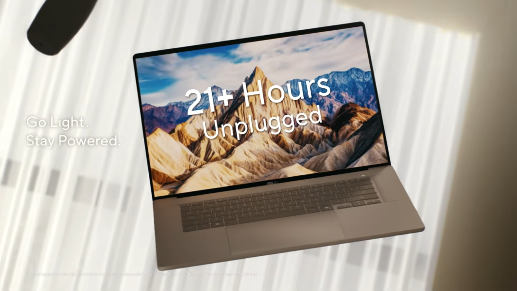 Imagem de um Asus Zenbook A16 flutuando em vídeo promocional. A tela mostra o texto "21 + Hours"