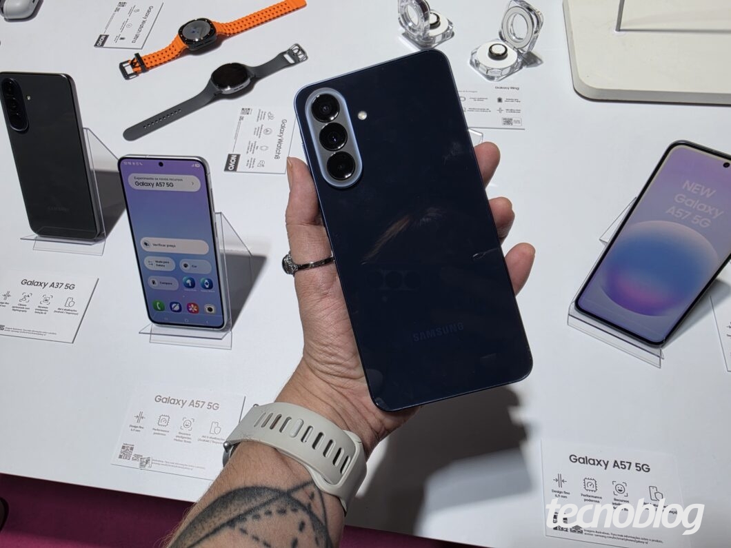 Smartphone Samsung Galaxy A57 5G em mãos, mostrando a traseira com câmera tripla e o sistema Galaxy AI