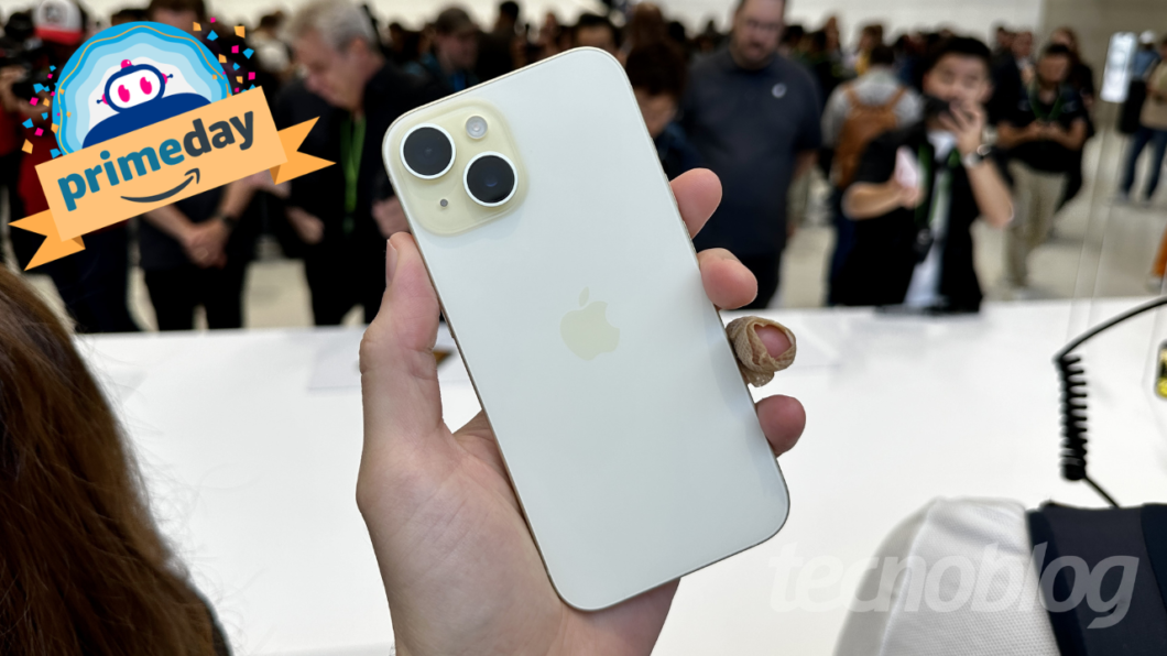 Pessoa segurando um celular iPhone branco em evento, com texto “primeday” no canto superior esquerdo