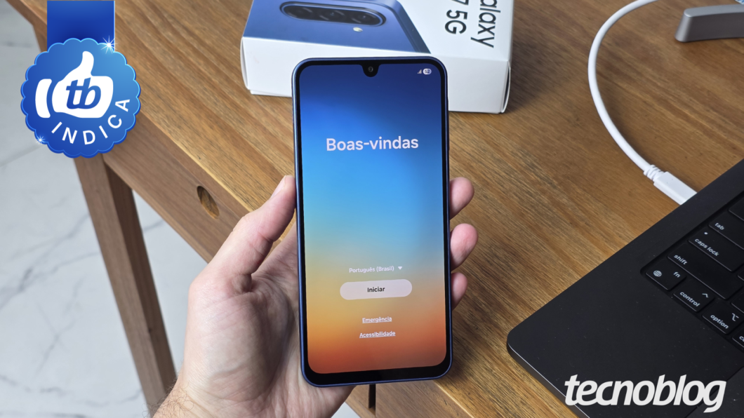 Celular Samsung Galaxy A17 5G na mão, exibindo tela de boas-vindas com opções Iniciar, Emergência e Acessibilidade