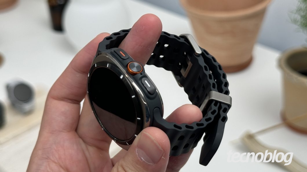 Pulseira do Galaxy Watch Ultra com o visor, sendo segurado na mão para mostrar o ajuste da alça