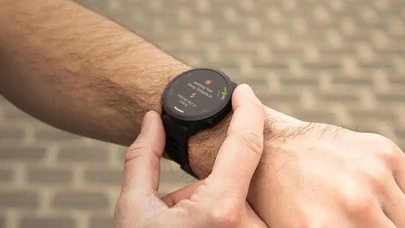 Relógio Garmin Forerunner 55 no pulso, com GPS para monitorar ritmo e velocidade durante treinos