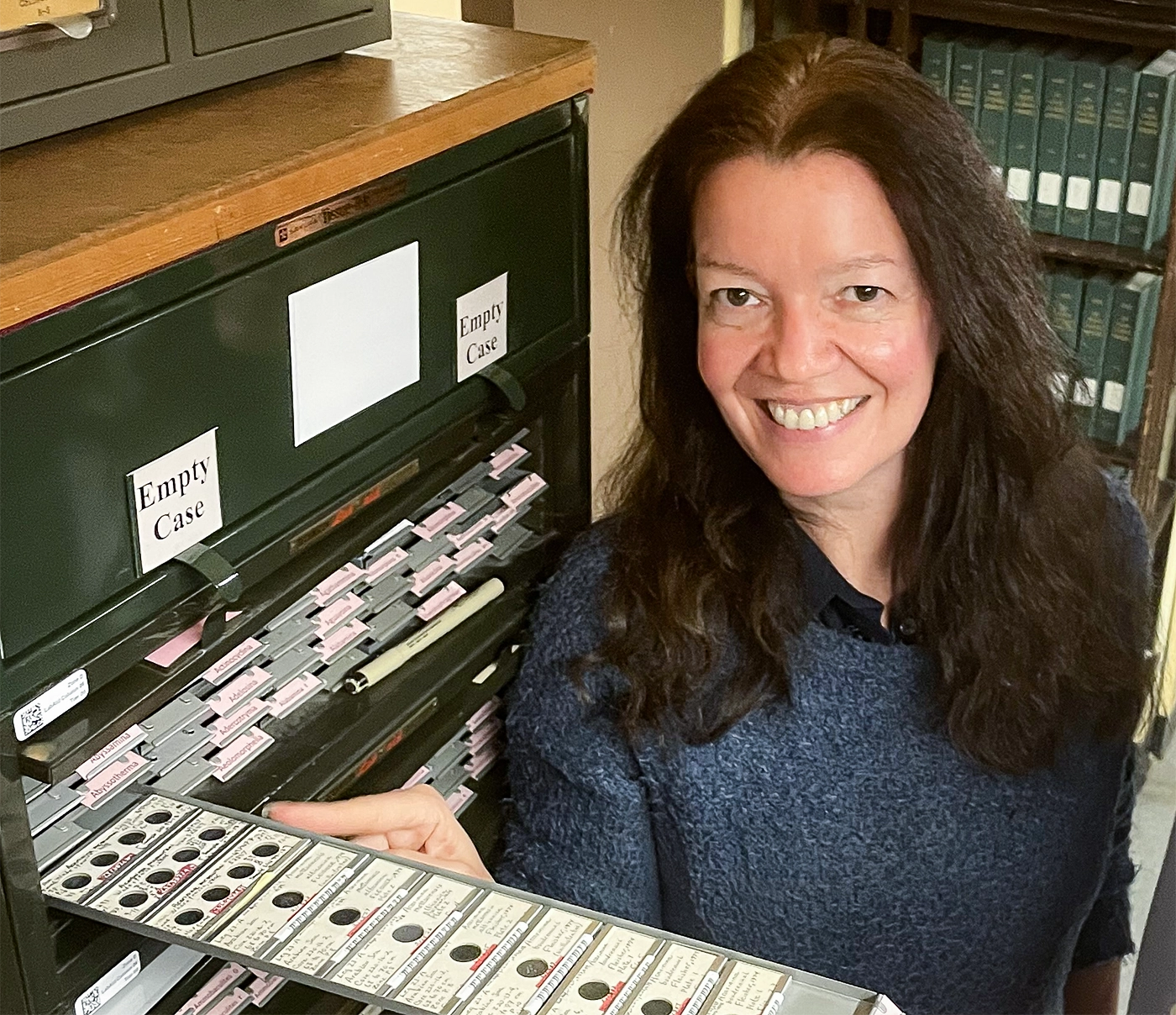Bridget Wade points to a slide in a drawer.