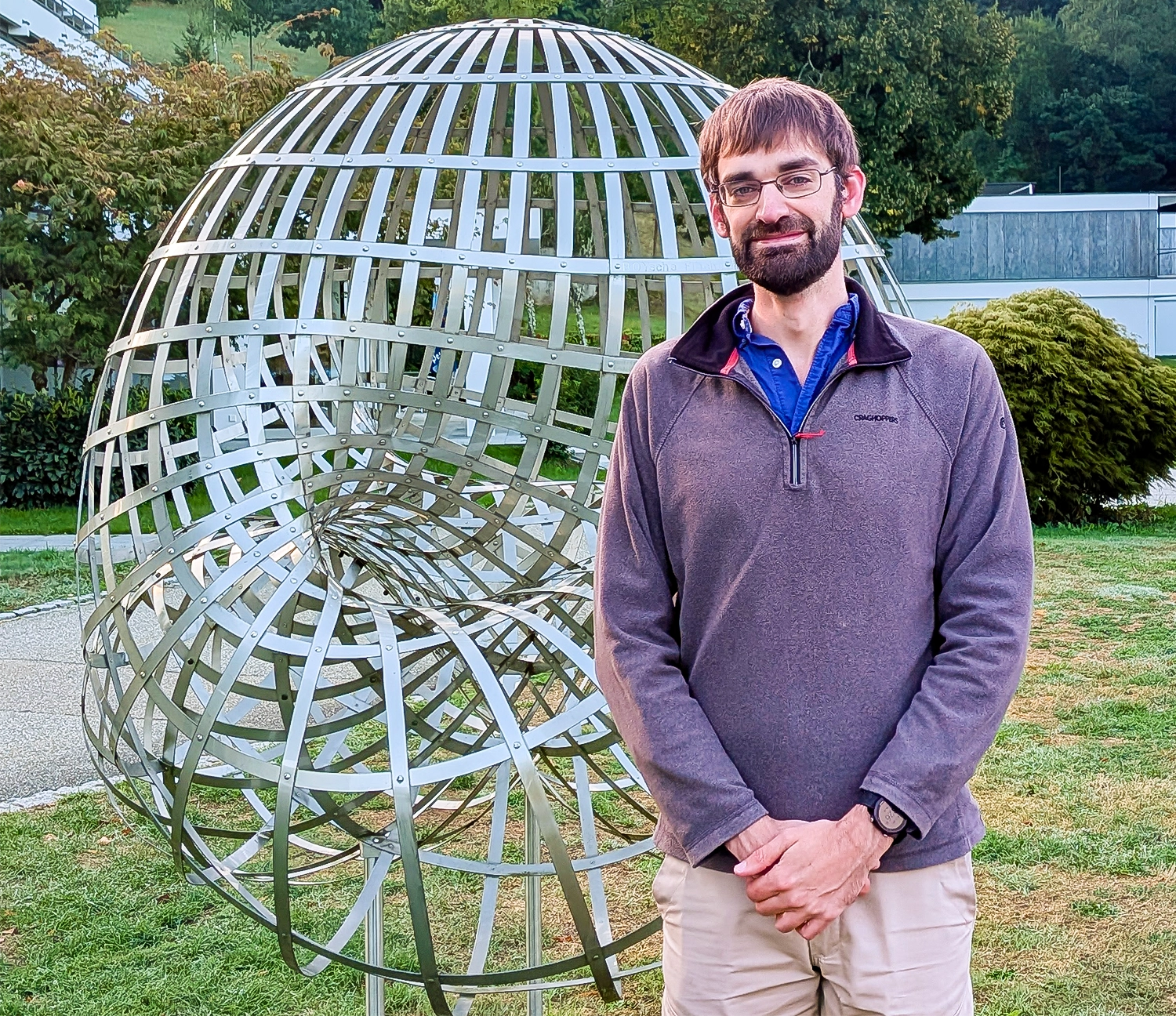 Man standing in front of a sculpture.