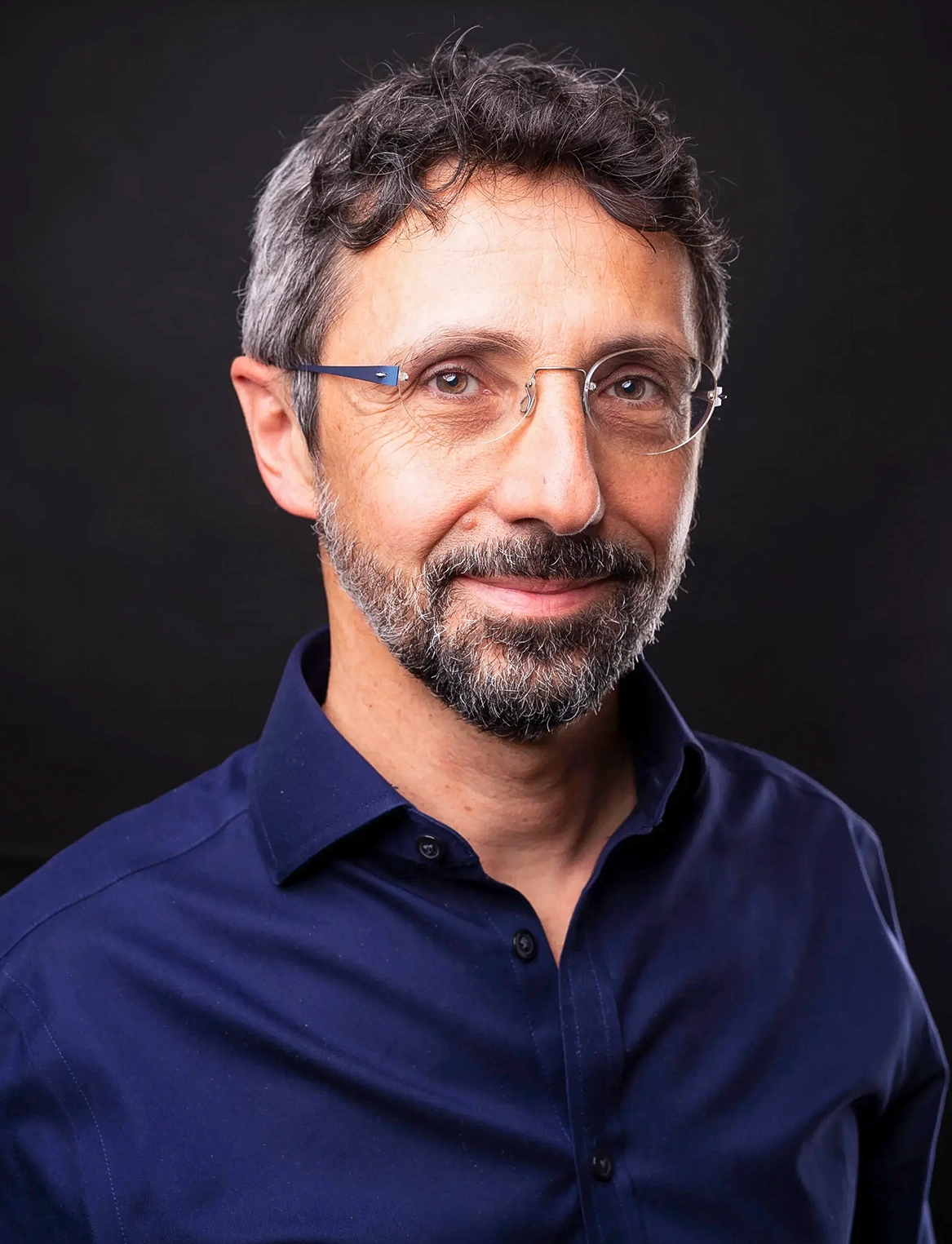 A man in glasses against a black background