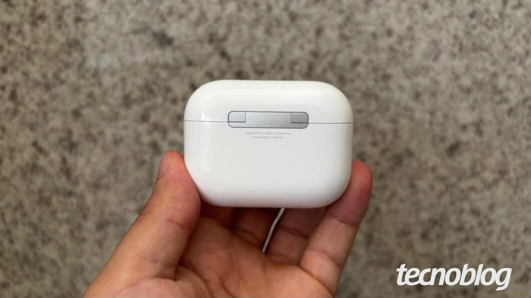 Case do AirPods Pro 3 sendo segurado por uma mão e mostrando a parte traseira.