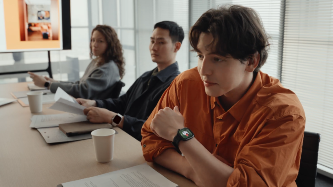 Homem usando o Huawei Watch Fit 5 Pro durante uma reunião.
