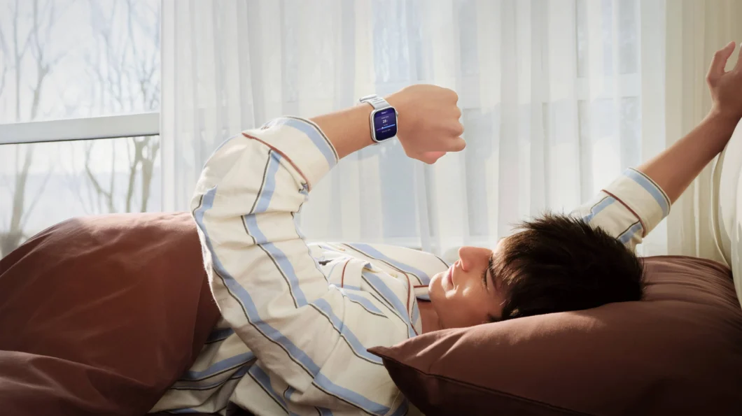 Homem se espreguiçando na cama e com o Huawei Watch Fit 5 Pro no pulso esquerdo