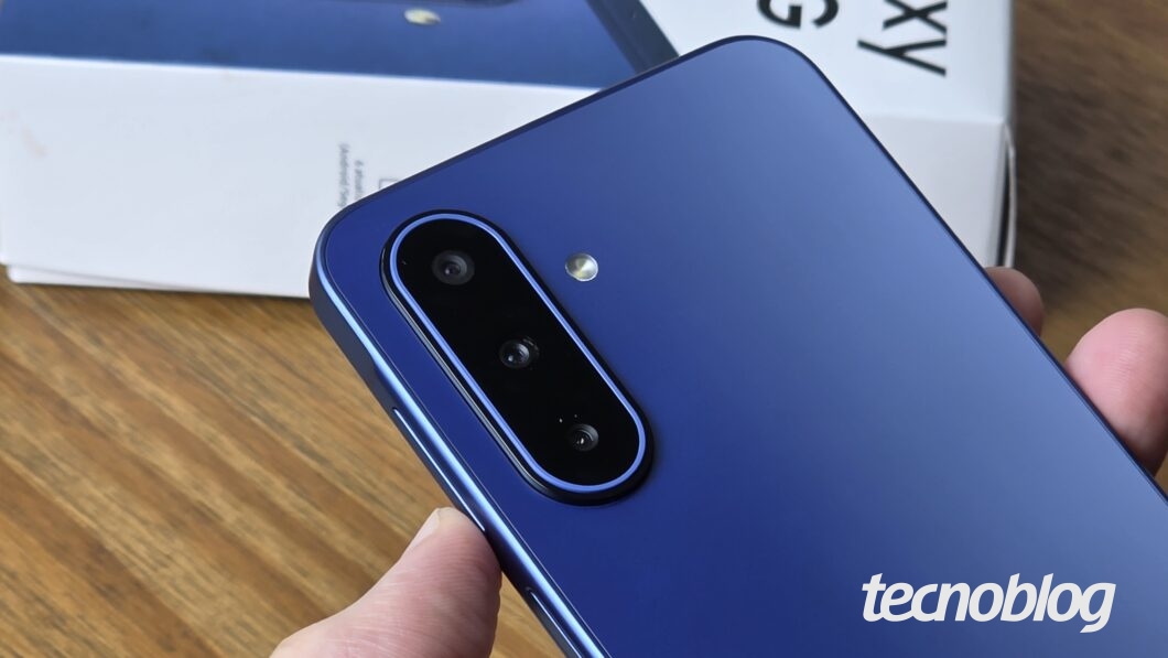 Câmera de celular Galaxy A57 vista de perto; aparelho tem traseira em azul reflexivo